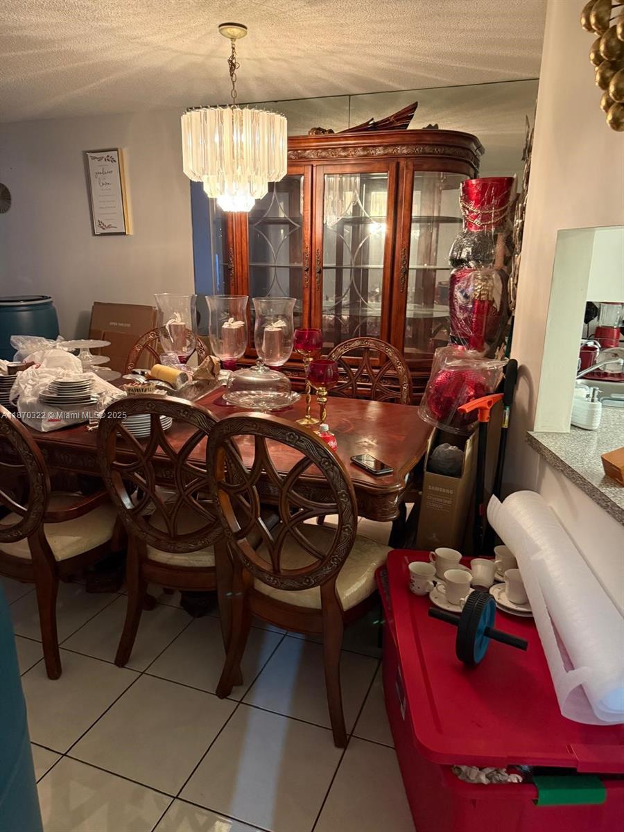 1710 Northeast 191st Street, Unit 3173 Miami, FL 33179 - Photo 16 of 18 a room with furniture a chandelier and a mirror