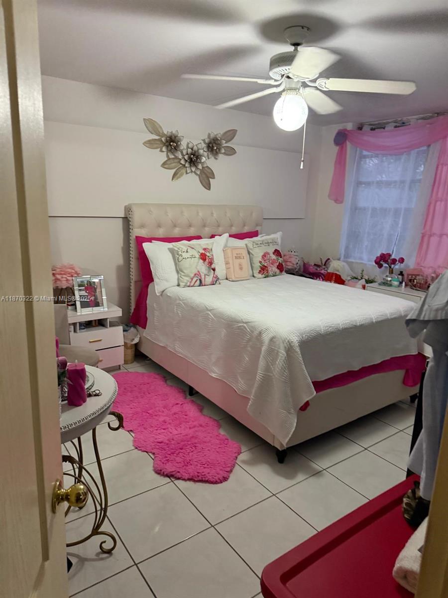 1710 Northeast 191st Street, Unit 3173 Miami, FL 33179 - Photo 2 of 18 a bedroom with a bed and a chandelier