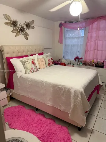 a bedroom with a bed and a potted plant