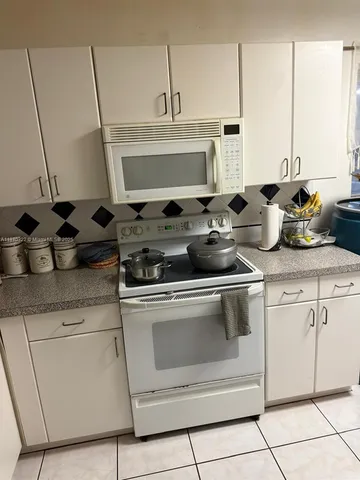 a stove top oven sitting inside of a kitchen