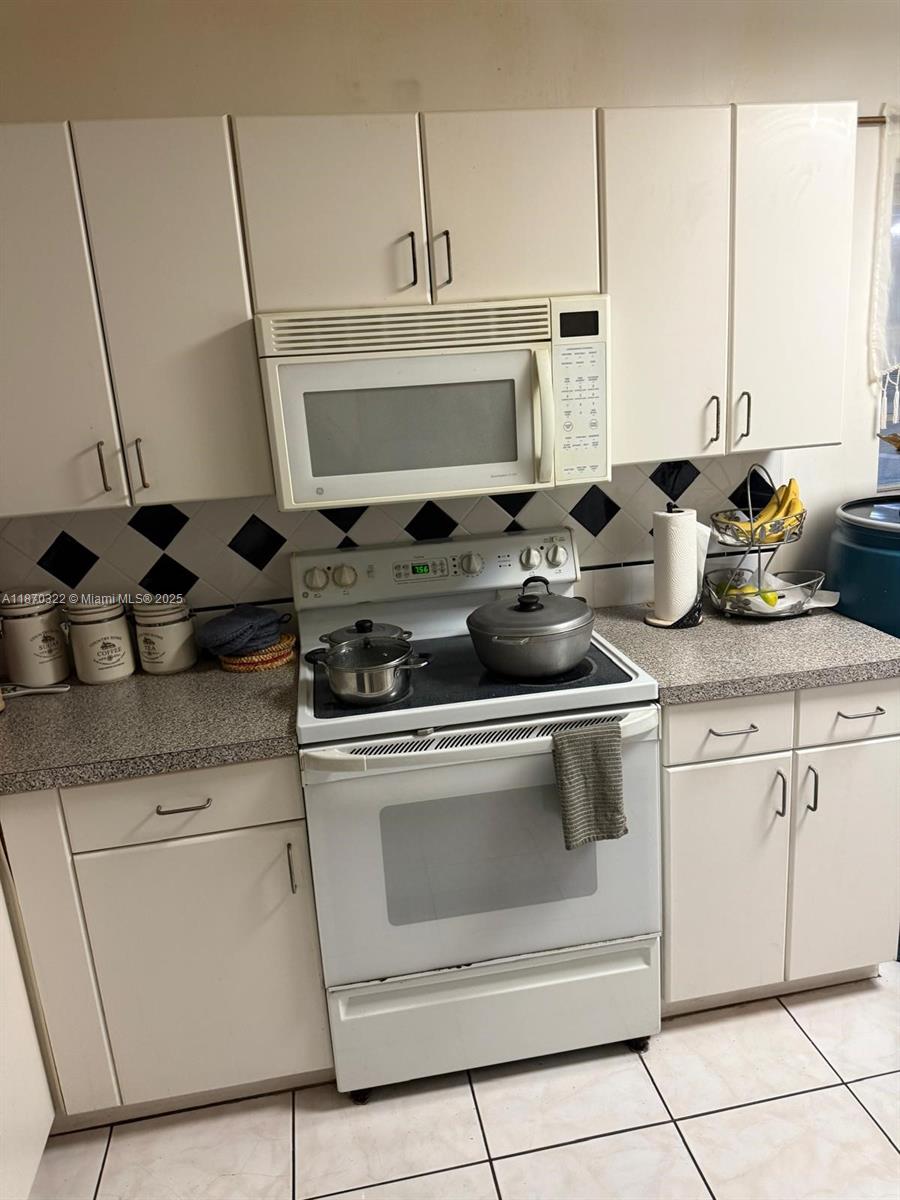 1710 Northeast 191st Street, Unit 3173 Miami, FL 33179 - Photo 9 of 18 a stove top oven sitting inside of a kitchen