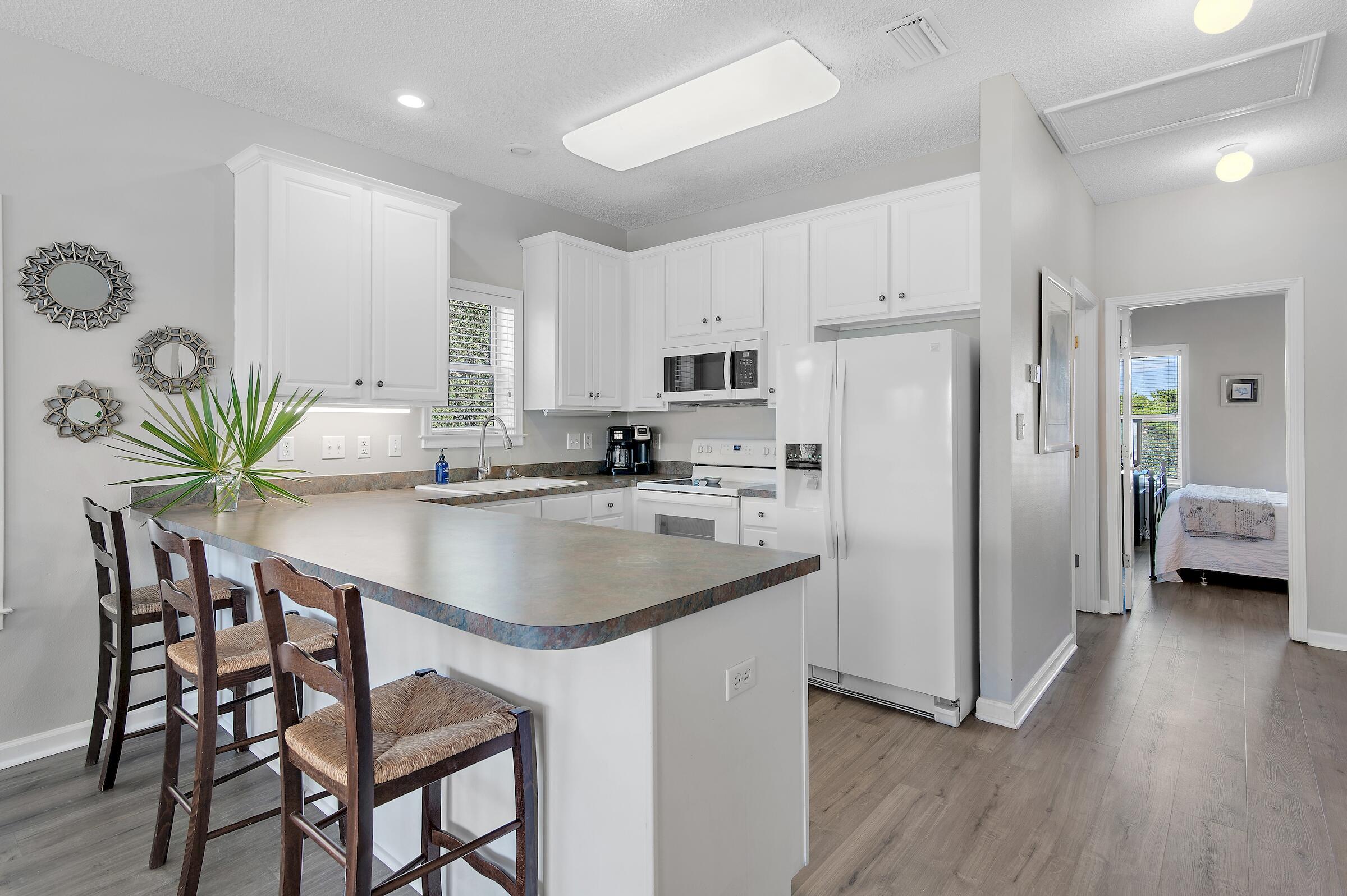 69 Seabreeze Trail Inlet Beach, FL 32461 - Photo 11 of 40 a kitchen with stainless steel appliances a sink a table and chairs