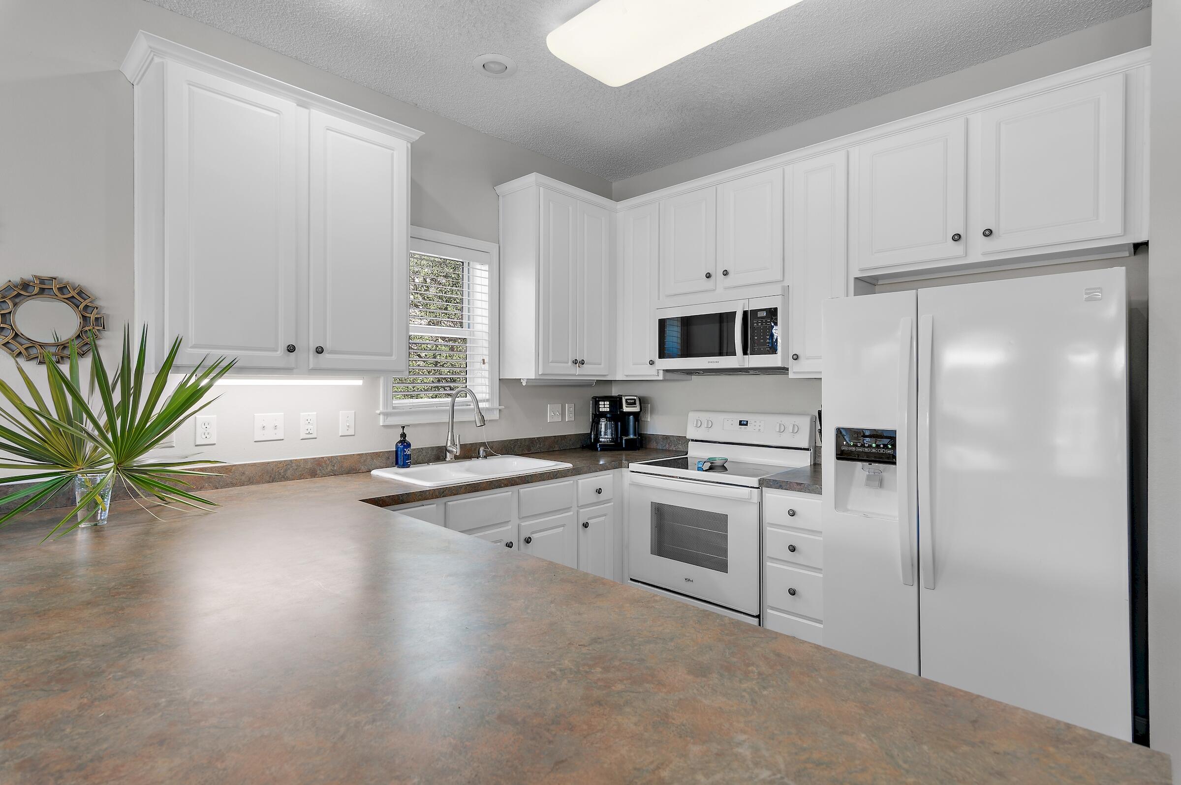 69 Seabreeze Trail Inlet Beach, FL 32461 - Photo 12 of 40 a kitchen with granite countertop a stove a sink and a refrigerator