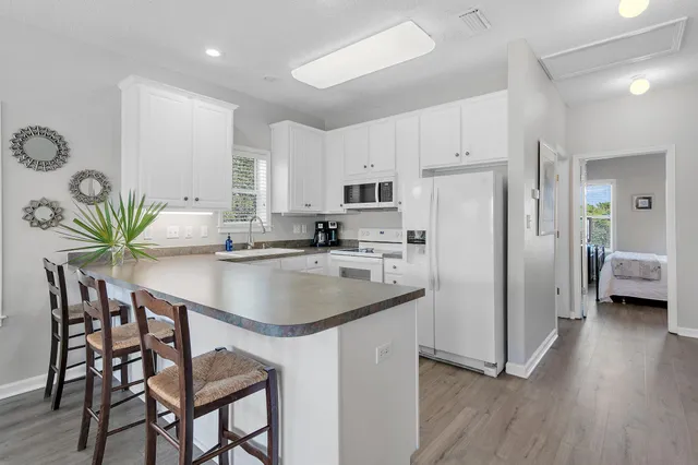 a kitchen with granite countertop a stove a sink and a refrigerator