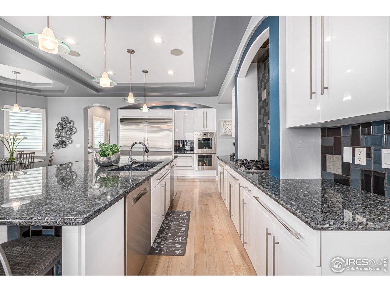285 Commander Drive Erie, CO 80516 - Photo 16 of 40 a kitchen with stainless steel appliances granite countertop a sink a stove and a wooden floors