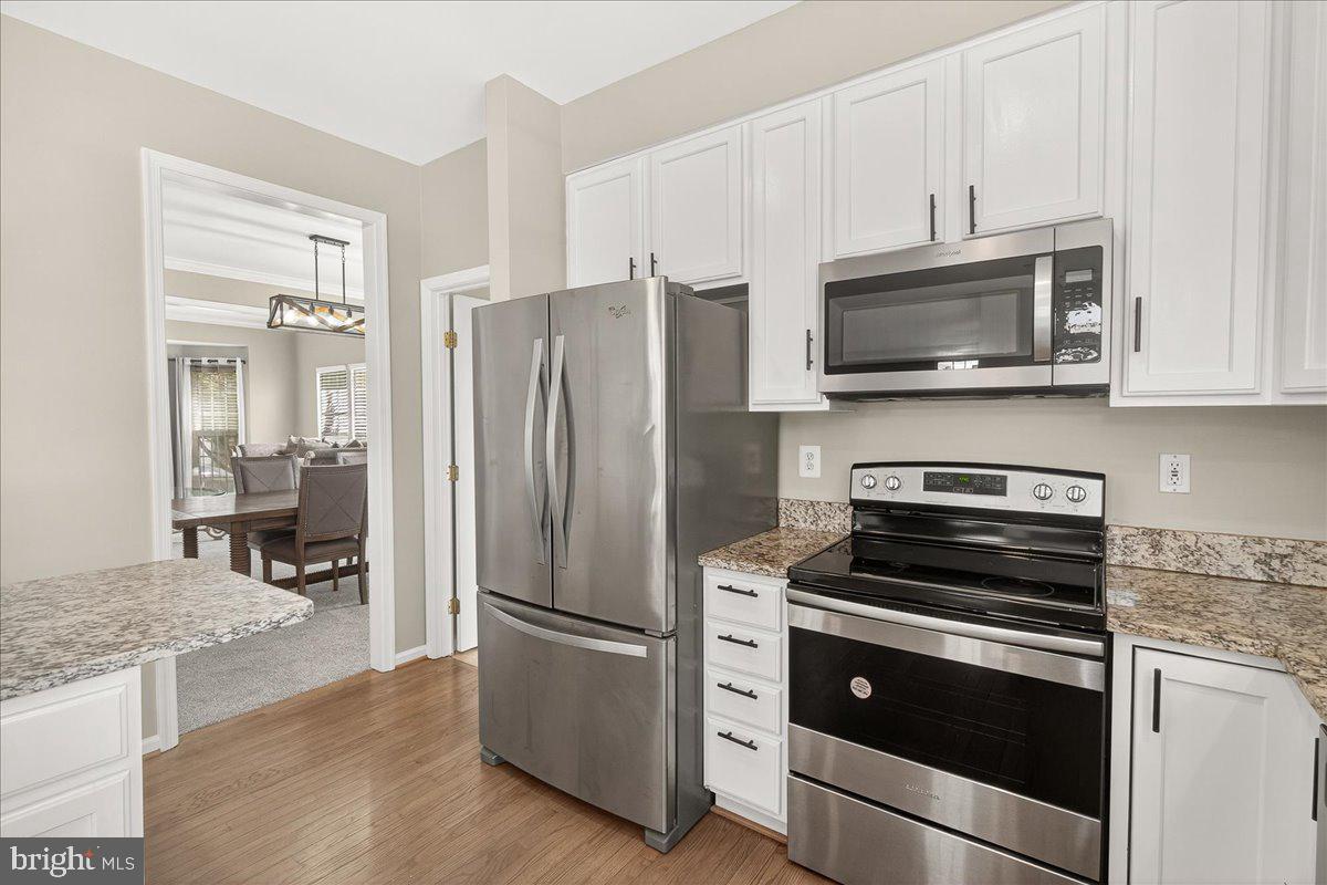 1308 Crossbow Road Mount Airy, MD 21771 - Photo 18 of 55 a kitchen with granite countertop a refrigerator stove and microwave
