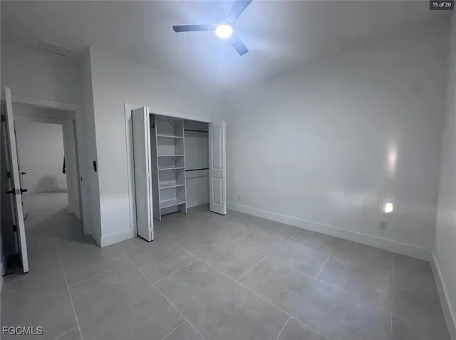 an empty room with a cabinet and a refrigerator