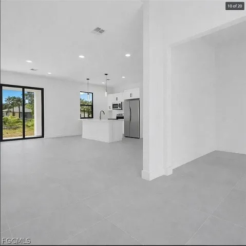 an empty room with a kitchen and a window