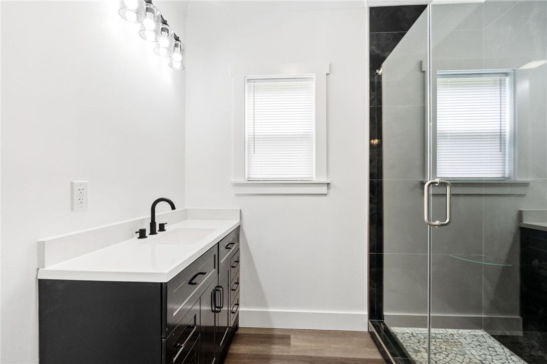 914 Smith Grove Road Easley, SC 29640 - Photo 19 of 37 A sleek vanity with contemporary black hardware complements the glass-enclosed shower, featuring textured tile flooring.