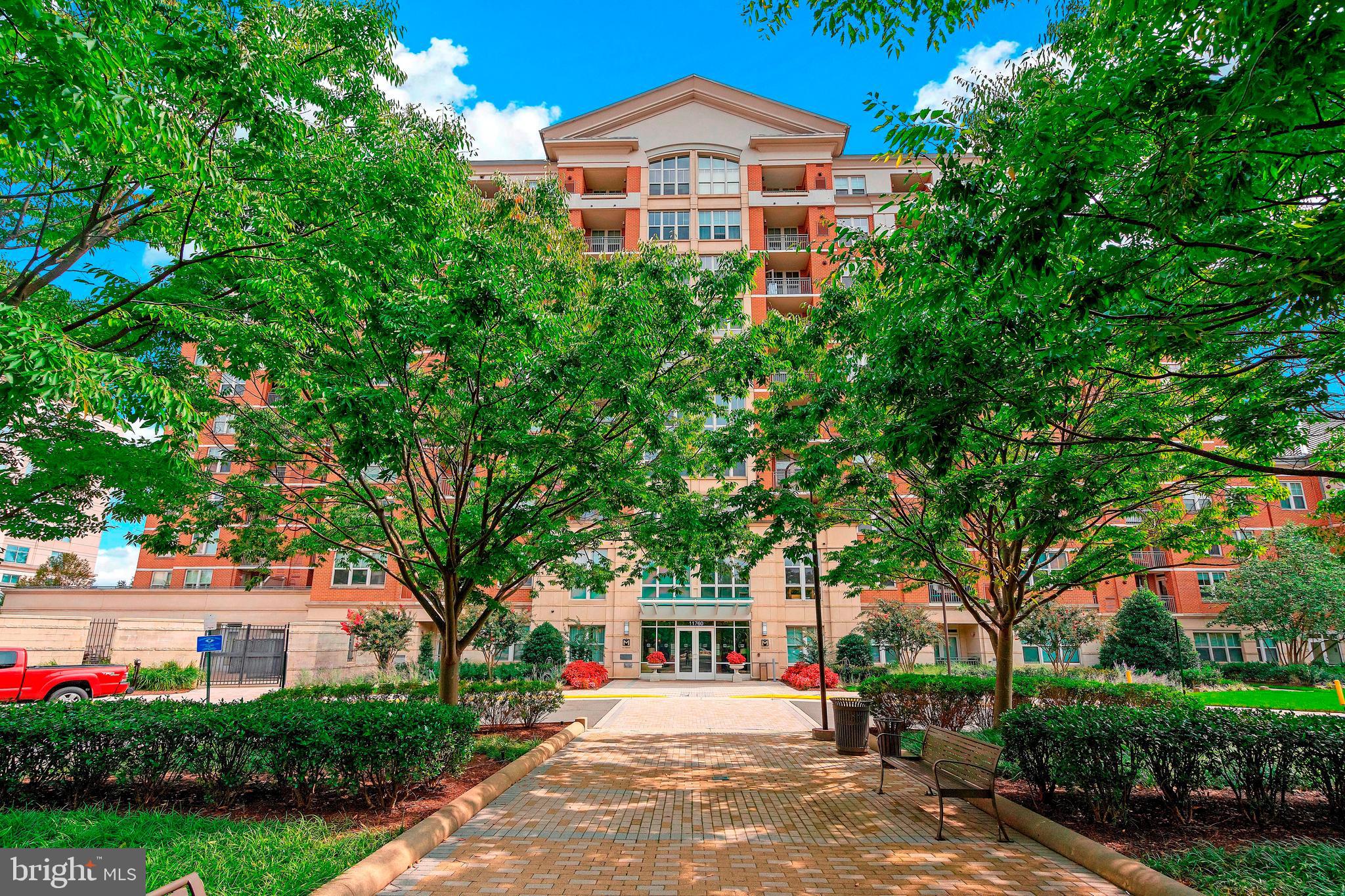 11760 Sunrise Valley Drive, Unit 209 Reston, VA 20191 - Photo 1 of 23 a front view of a house with a yard and trees