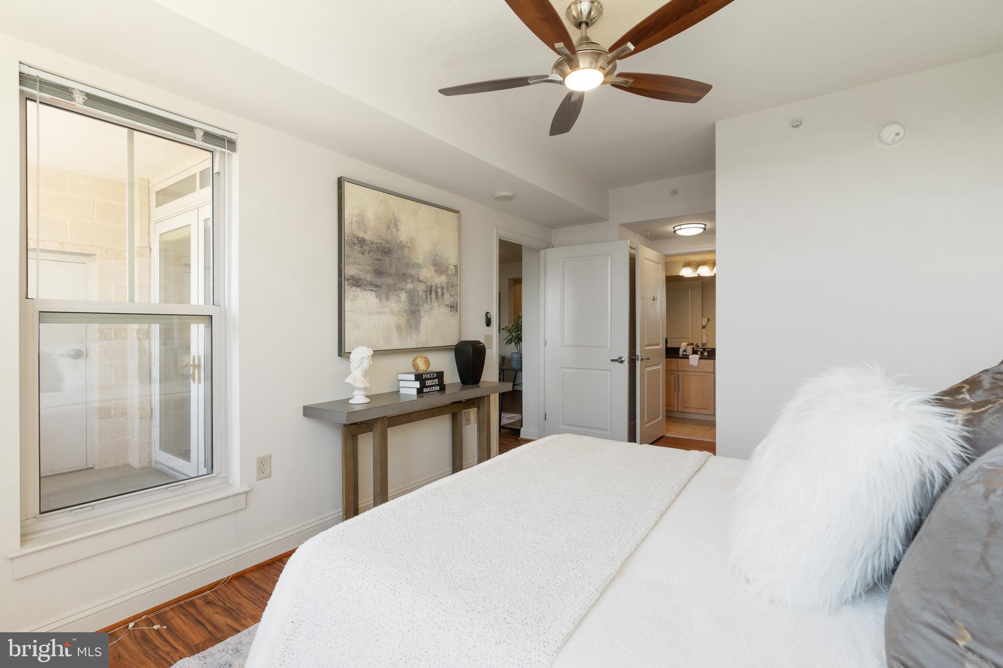 11760 Sunrise Valley Drive, Unit 209 Reston, VA 20191 - Photo 12 of 23 a bedroom with a large bed and a chandelier