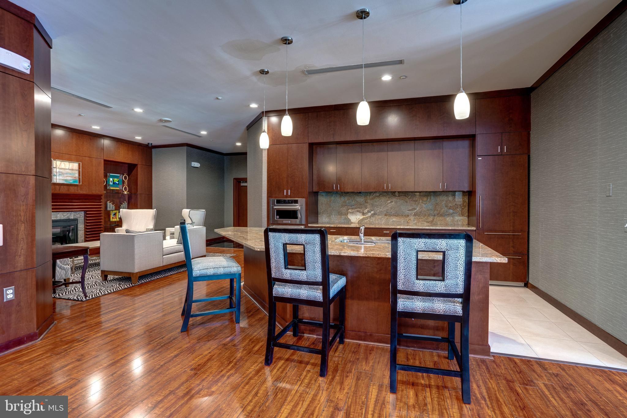 11760 Sunrise Valley Drive, Unit 209 Reston, VA 20191 - Photo 18 of 23 a kitchen with stainless steel appliances dining table chairs and wooden floor