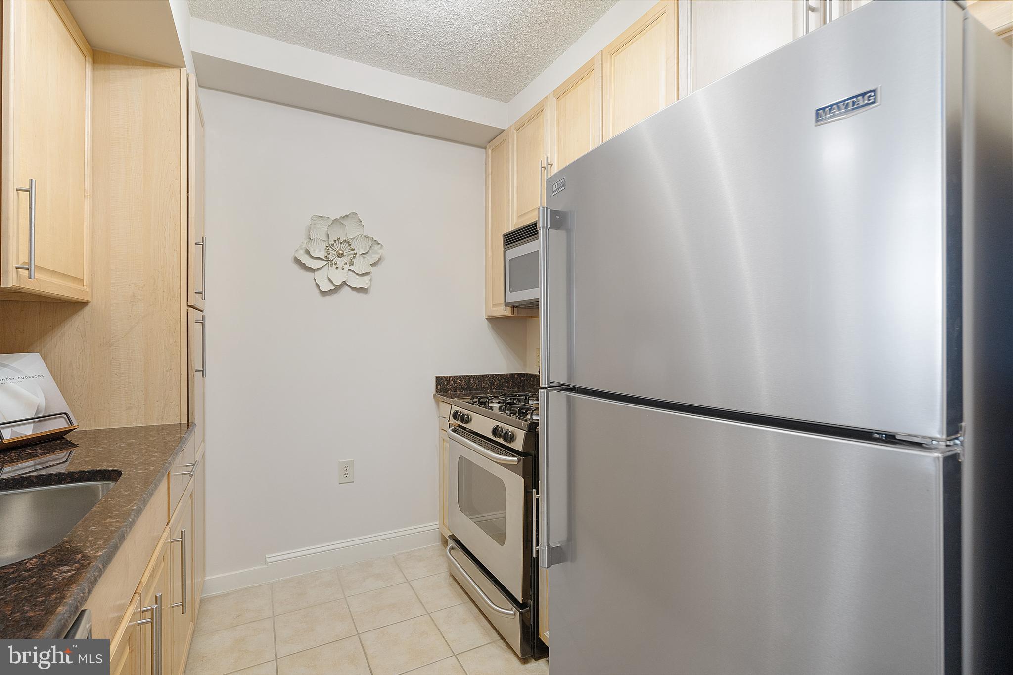 11760 Sunrise Valley Drive, Unit 209 Reston, VA 20191 - Photo 2 of 23 a kitchen with a refrigerator and a stove