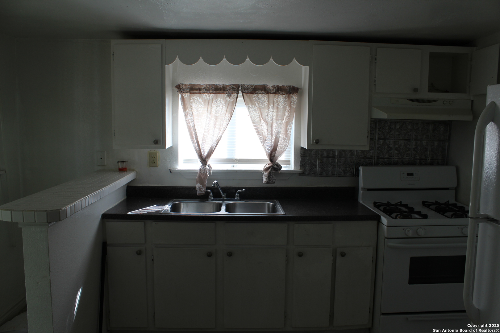 859 Thompson Place, Unit 3 San Antonio, TX 78226 - Photo 2 of 5 a kitchen with granite countertop a sink a stove and cabinets
