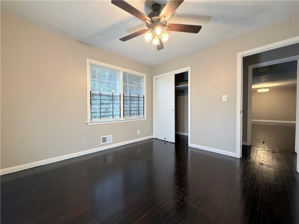 2397 Tilson Road Decatur, GA 30032 - Photo 14 of 22 an empty room with wooden floor chandelier fan and windows