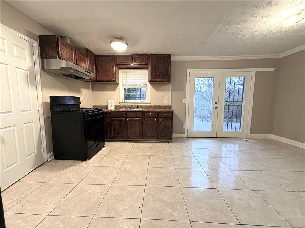 2397 Tilson Road Decatur, GA 30032 - Photo 6 of 22 a kitchen with granite countertop a refrigerator and a stove top oven