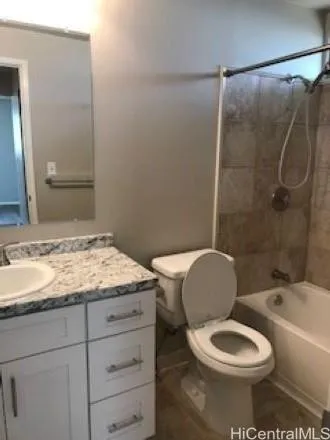 a bathroom with a granite countertop toilet sink and mirror
