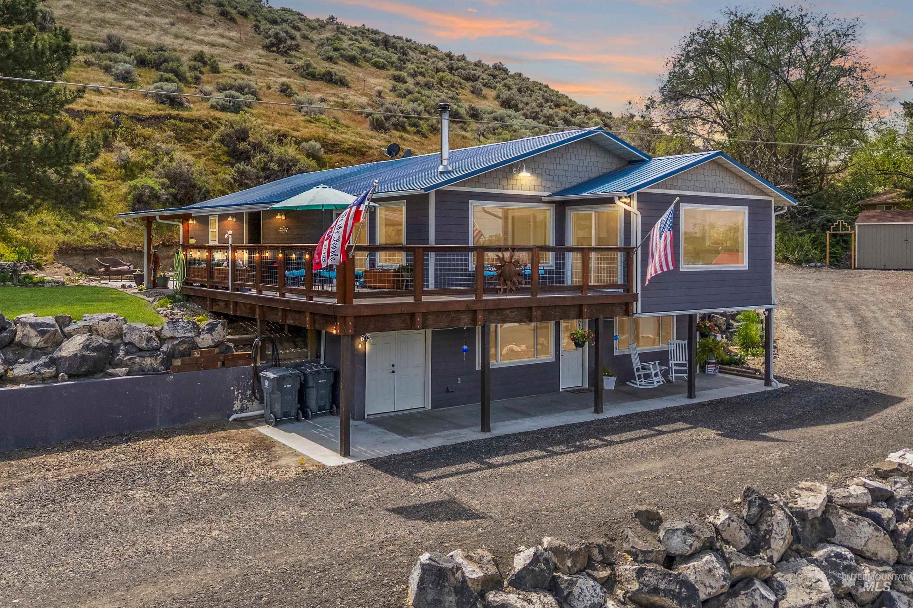 Contemporary split-level residence featuring a blue metal roof and dark grey siding
