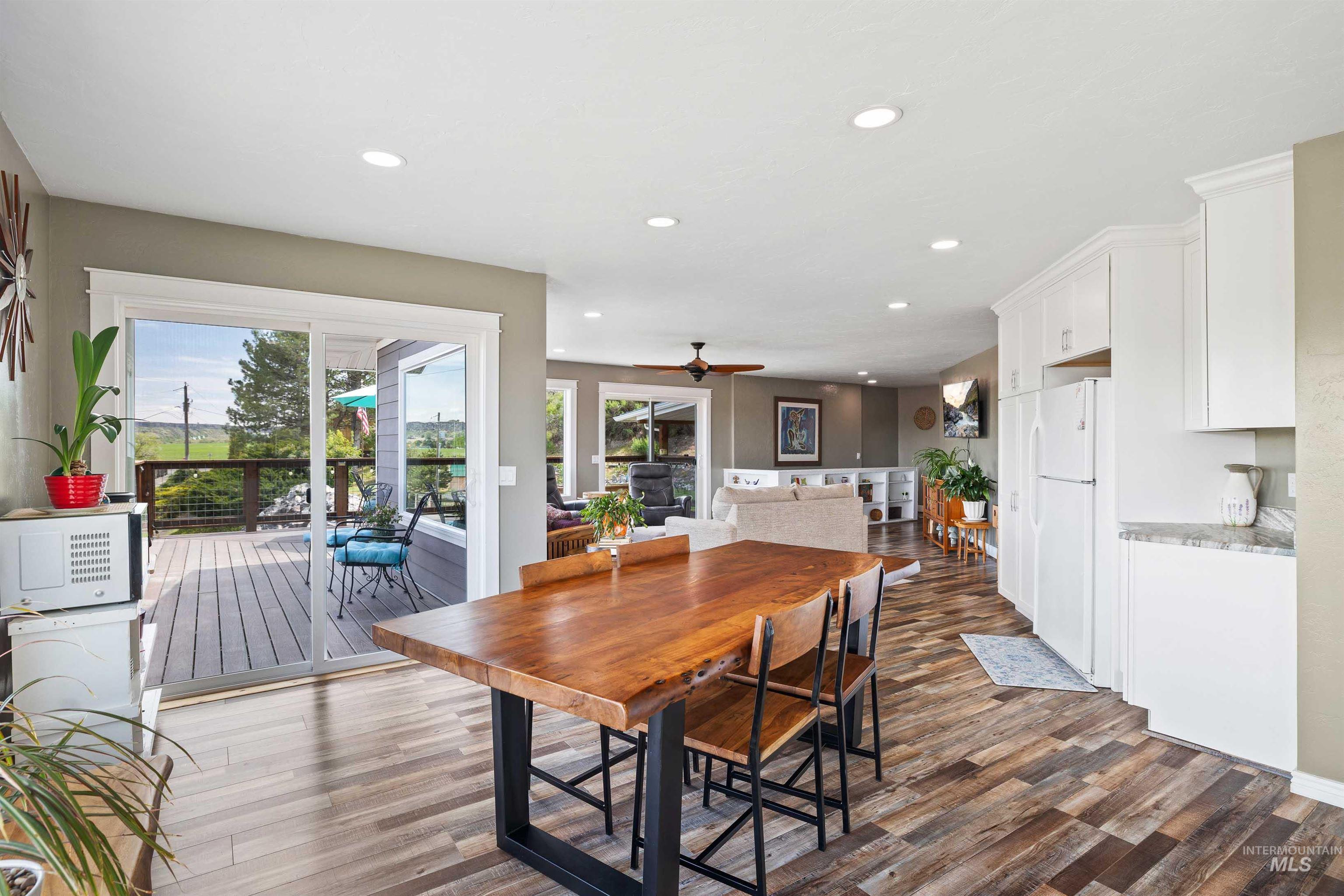 11 Bell Rapids Road Hagerman, ID 83332 - Photo 22 of 40 Open concept living space featuring wood-finish flooring, recessed lighting, a sliding glass door to an outdoor deck, white kitchen cabinetry, and an eat-in kitchen island with a wood countertop