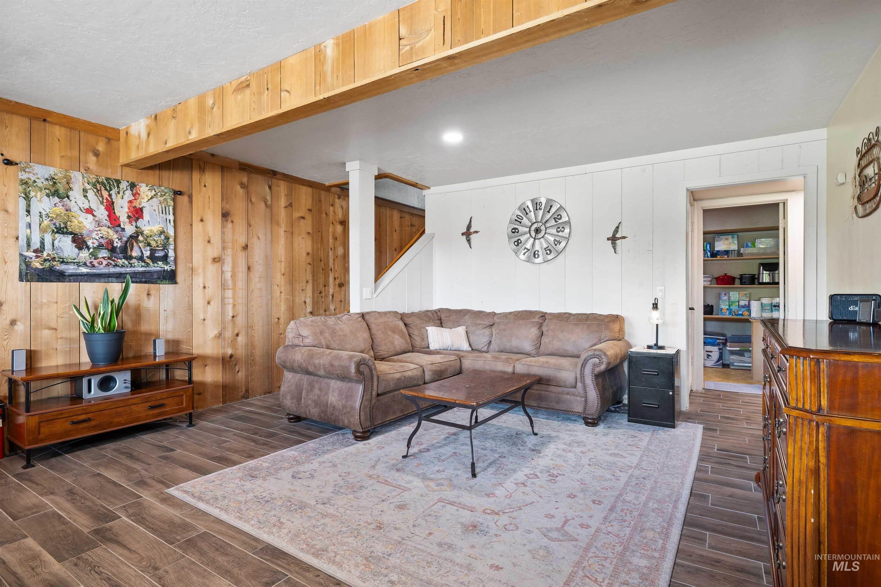 11 Bell Rapids Road Hagerman, ID 83332 - Photo 28 of 40 Living area with wood-finish flooring, exposed wood beams, and a wood-paneled accent wall