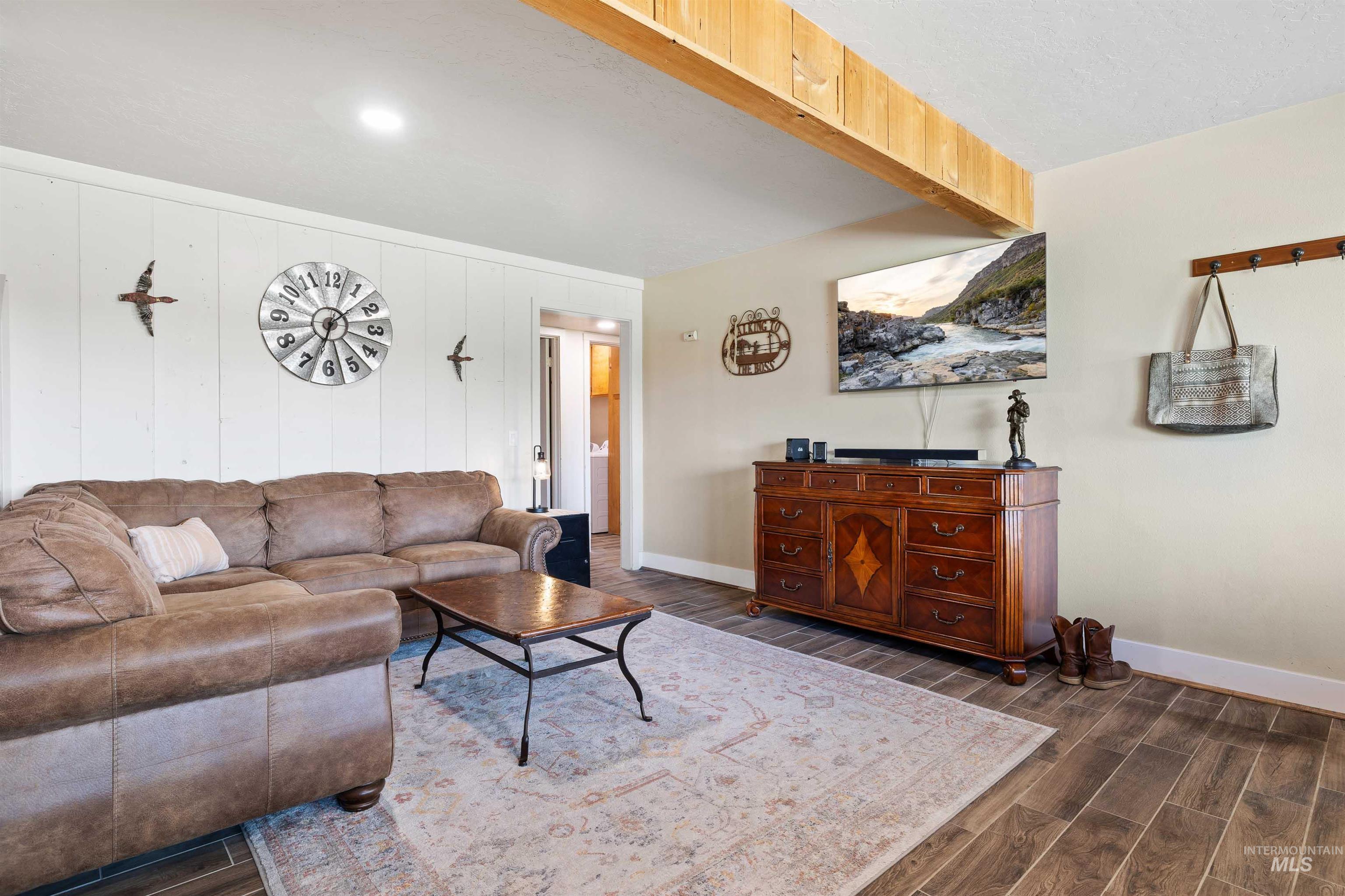 11 Bell Rapids Road Hagerman, ID 83332 - Photo 30 of 40 Living area featuring wood-finish flooring, a white paneled accent wall, a prominent wooden ceiling beam, and recessed lighting