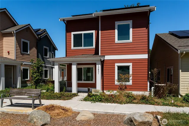 a brick house with a yard and large tree