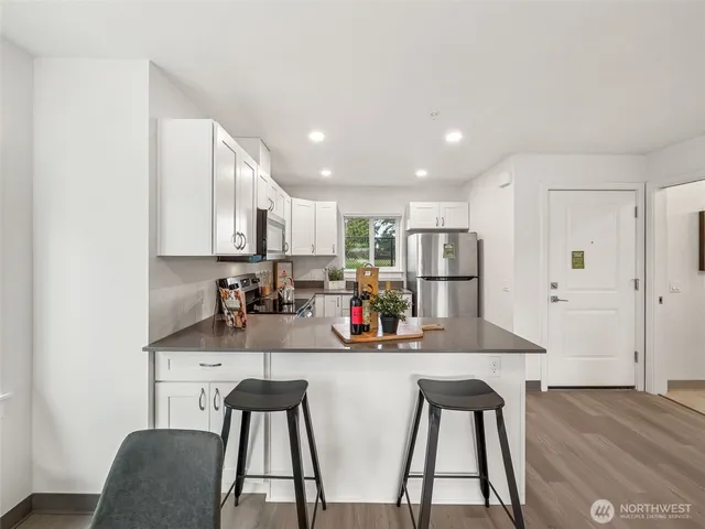 a kitchen with stainless steel appliances granite countertop a sink refrigerator and cabinets