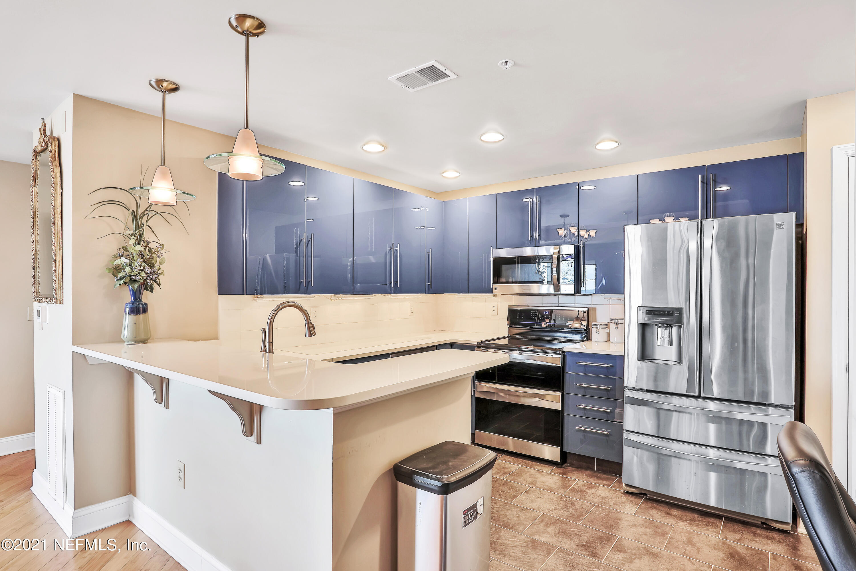 a kitchen with kitchen island a counter top space stainless steel appliances and cabinets