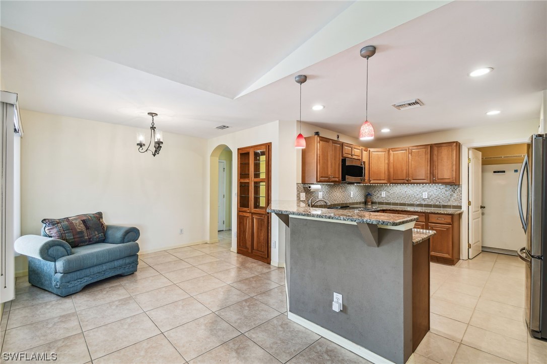 430 Rathburn Street Lehigh Acres, FL 33974 - Photo 9 of 50 a kitchen with kitchen island a counter top space a sink stainless steel appliances and cabinets