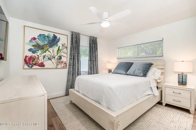 a bedroom with a large bed a flat tv screen and a dresser