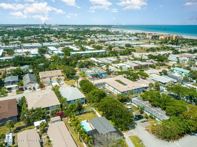 an aerial view of residential houses with outdoor space and trees