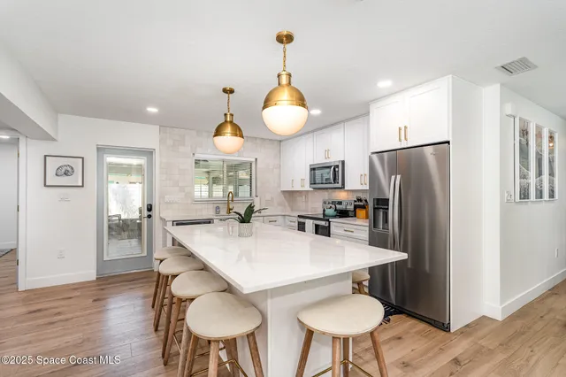 a living room with furniture kitchen view and a flat screen tv