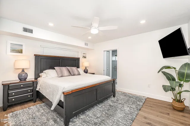 a bedroom with a large bed and a chandelier