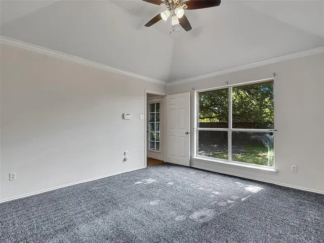 a view of a big room with a ceiling fan and window