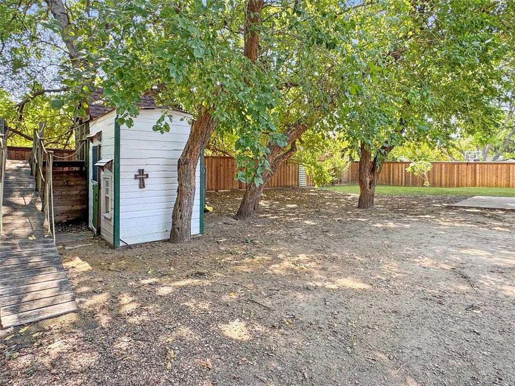 806 Glenwood Court McKinney, TX 75071 - Photo 20 of 29 a view of a backyard with large trees and a barn