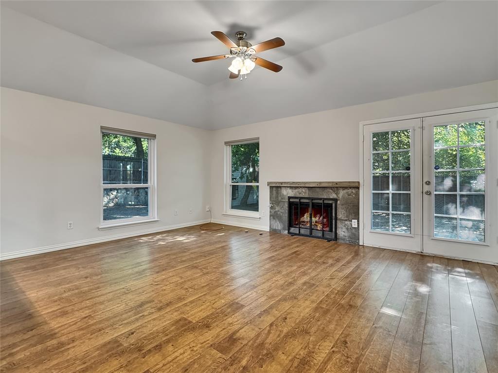 806 Glenwood Court McKinney, TX 75071 - Photo 7 of 29 a view of an empty room with wooden floor fireplace and a window