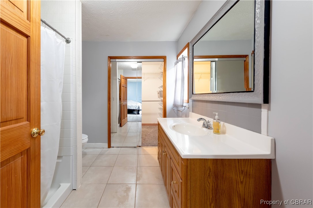 9534 Gee Farm Road Gloucester, VA 23061 - Photo 33 of 48 Full bathroom with a textured ceiling, toilet, shower with separate bathtub, and vanity