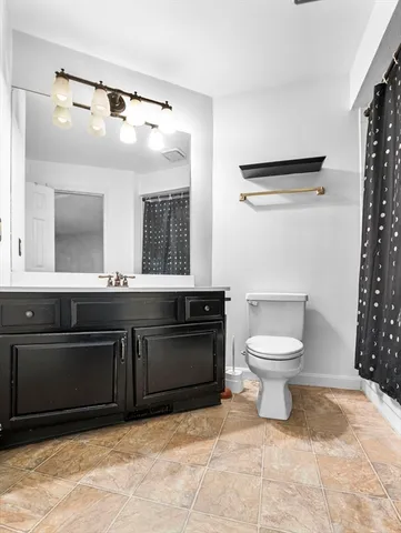 a spacious bathroom with a toilet sink and mirror