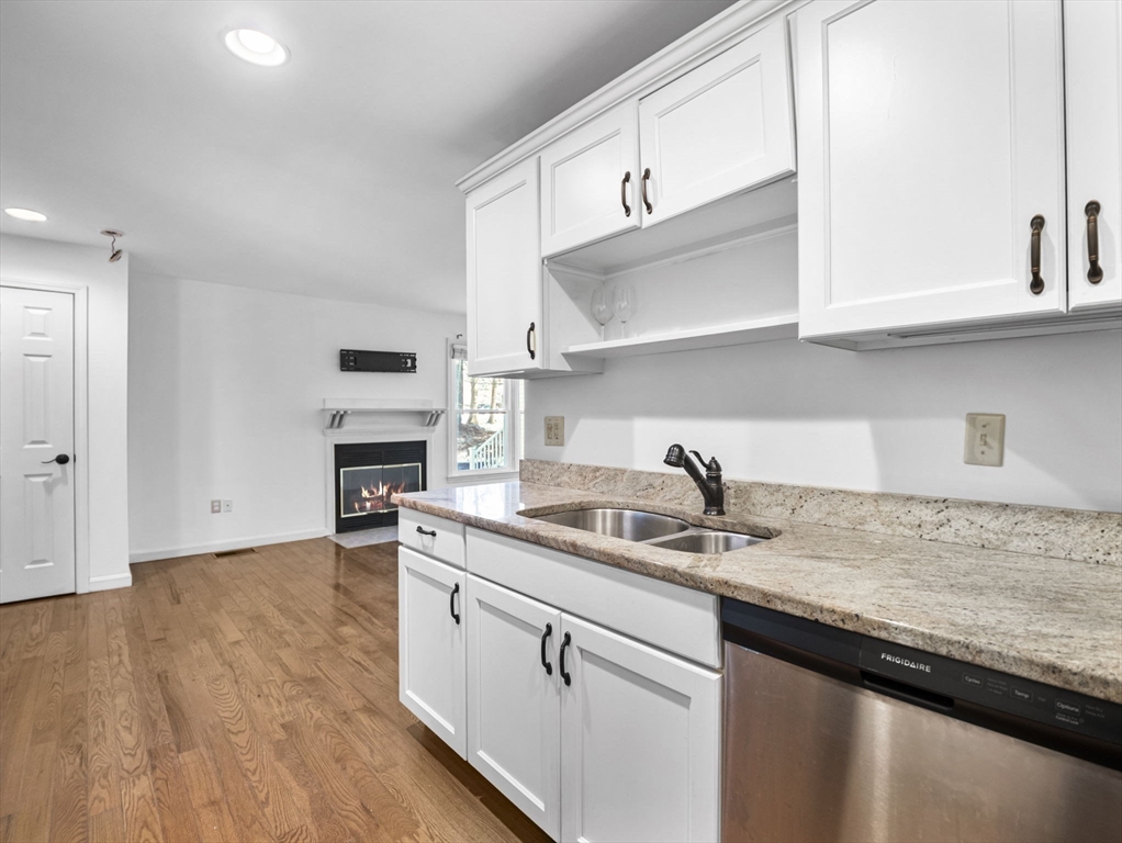600 County Street, Unit 404 Taunton, MA 02780 - Photo 4 of 26 a kitchen with stainless steel appliances granite countertop a sink dishwasher a stove and white cabinets with wooden floor