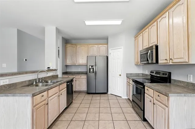 a kitchen with a sink stove top oven and refrigerator