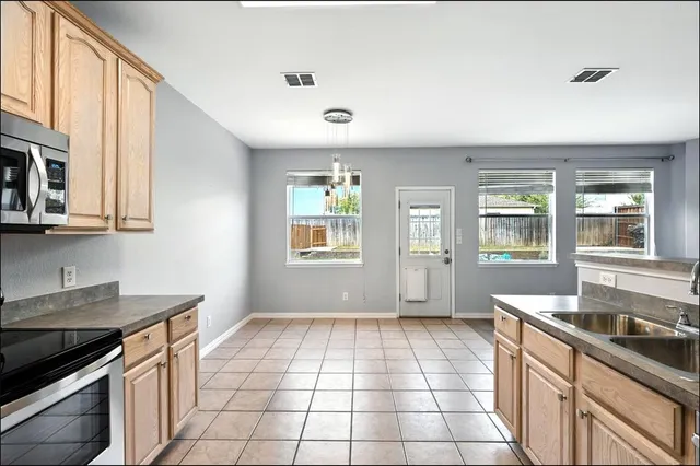 a kitchen with a sink a stove and cabinets