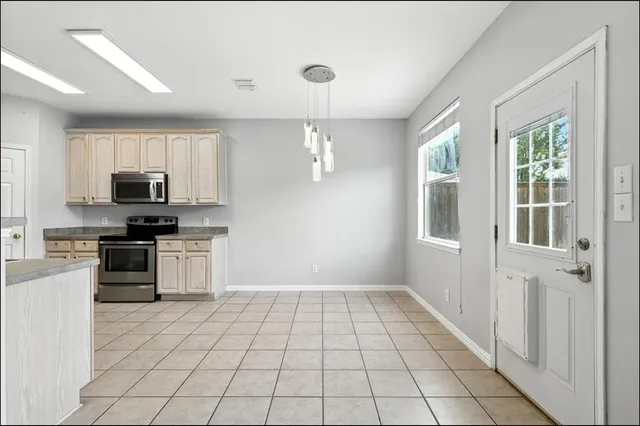 a kitchen with granite countertop a stove a sink and a refrigerator