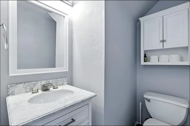 a bathroom with a toilet sink and mirror