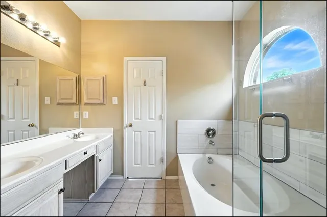 a bathroom with a tub sink and mirror