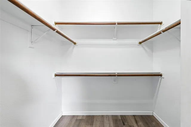 a view of walk in closet with empty racks