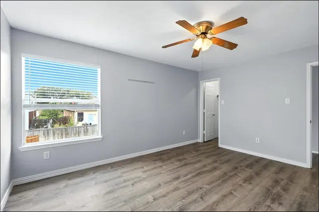 a view of an empty room with window and cabinet