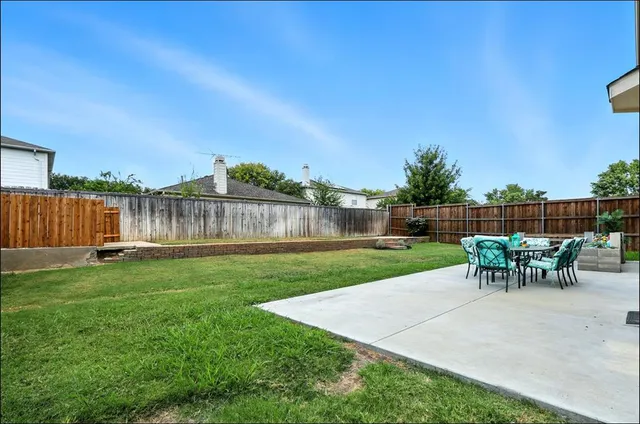 a view of a backyard with a garden and sitting area