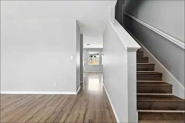 a view of a hallway with wooden floor and entryway