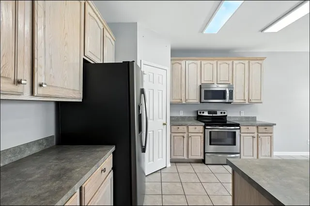 a kitchen with stainless steel appliances granite countertop a refrigerator and a stove top oven