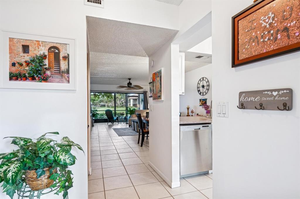2249 Southwest 15th Street, Unit 185 Deerfield Beach, FL 33442 - Photo 12 of 31 a hallway with painting and a potted plant